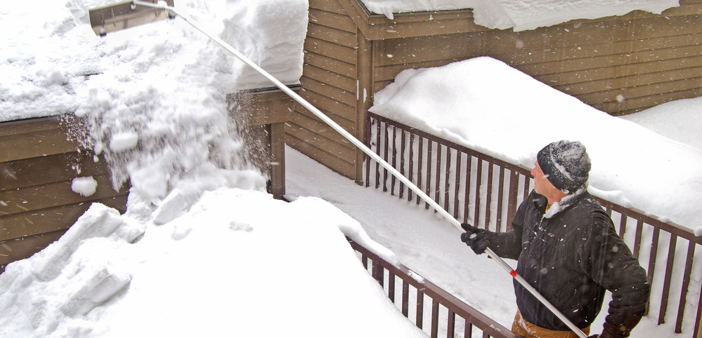 Man removing snow from roof