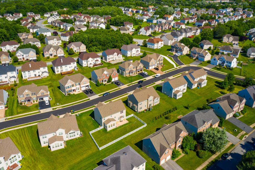 An aerial photo of residential homes with green lawns.