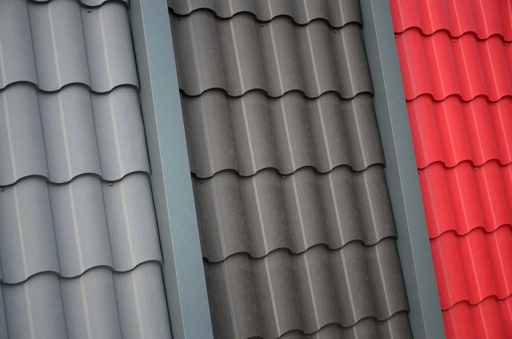 Samples of metal shingles side-by-side in light gray, dark gray, and bright red.