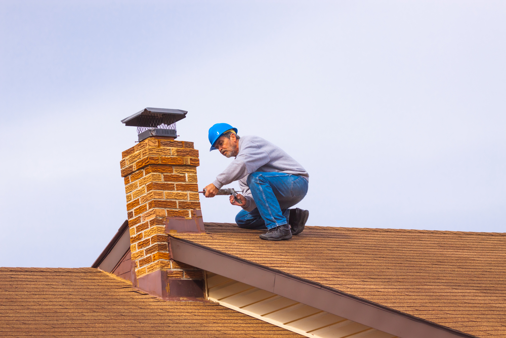 Man repairing chimney on roof