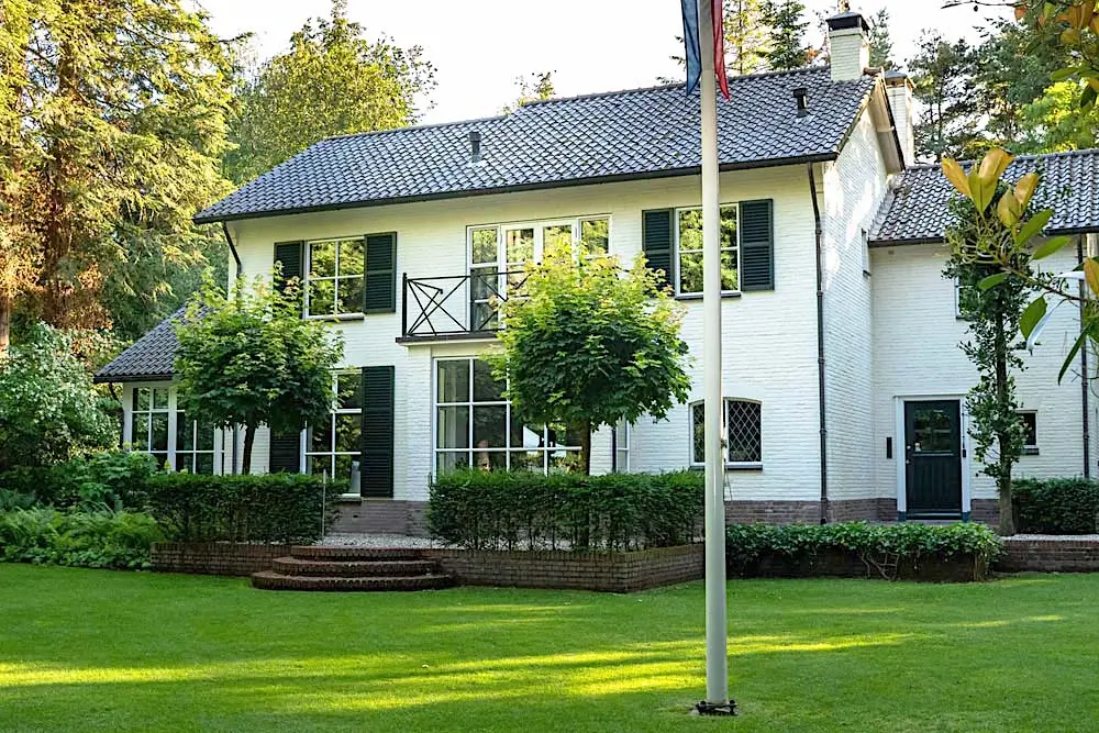a suburban home with trees close by to the house